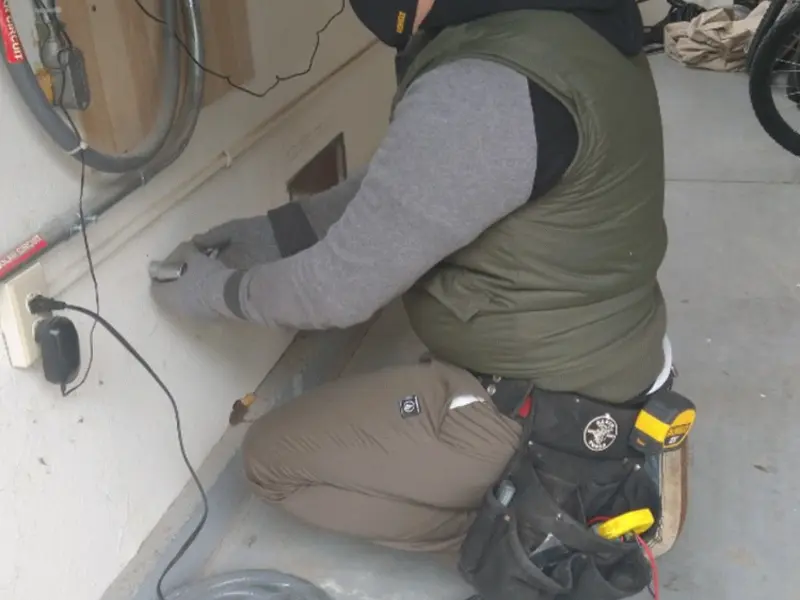 Electrician performing outlet wiring in a Vineland garage
